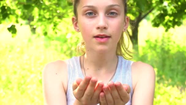 Девочка-подросток, дующая на руки блестками, замедленная съемка . — стоковое видео