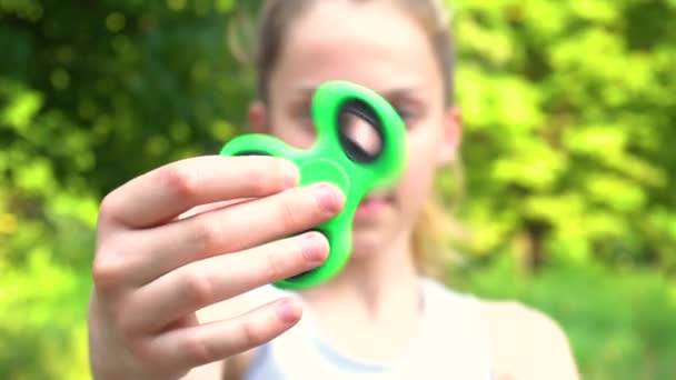 Adolescent fille filature spinner dans main — Video