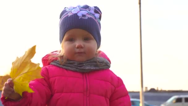 Schattig happy babymeisje met geel blad — Stockvideo