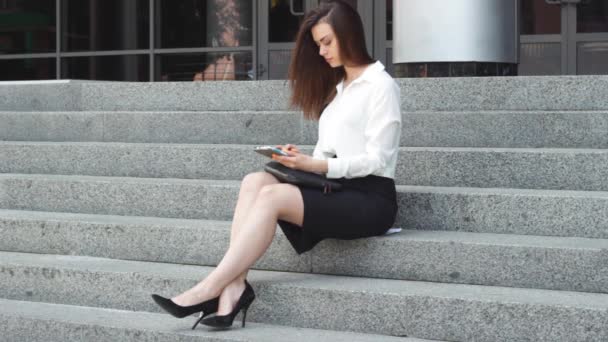 Businesswoman using tablet on steps — Stock Video