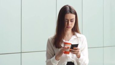 Sıcak içecek smartphone kullanarak ile yetişkin iş kadını