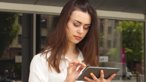 Empresária morena atraente usando tablet ao ar livre — Vídeo de Stock