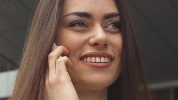 Бізнес-леді розмовляє по смартфону і посміхається — стокове відео