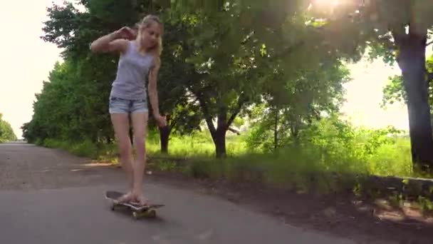 Dospívající dívka na koni skateboard v krajině — Stock video