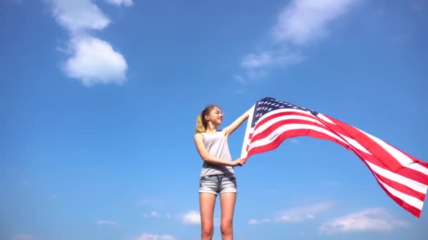 Female teenager girl holding American flag in nature — Stock Video