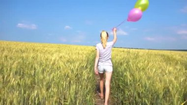 Balonlar alanında yavaş yürüyen genç kadınla