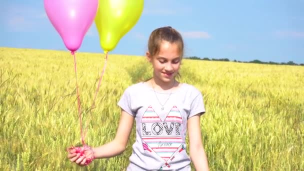 Meisje met ballonnen plezier in veld in slow motion — Stockvideo