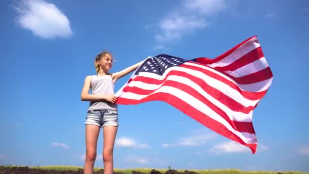 Feminino segurando bandeira dos EUA na natureza — Vídeo de Stock