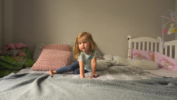 Nettes Mädchen kriecht auf dem Bett — Stockvideo