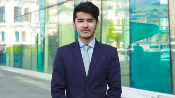 Молодой азиатский бизнесмен стоит на улице — стоковое видео