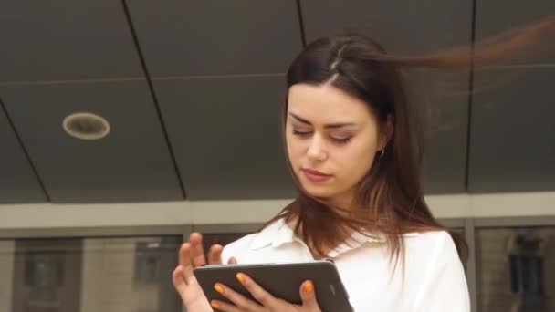 Молода бізнес-леді використовує планшет у вітряний день — стокове відео