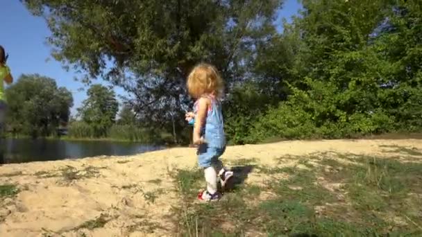 Chica jugando en la orilla cerca de la madre — Vídeos de Stock