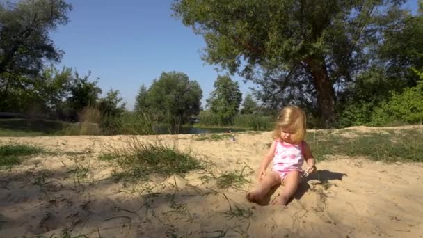 Смешная девочка, играющая на берегу — стоковое видео