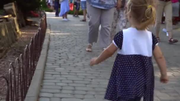 Mädchen läuft in überfülltem Park — Stockvideo