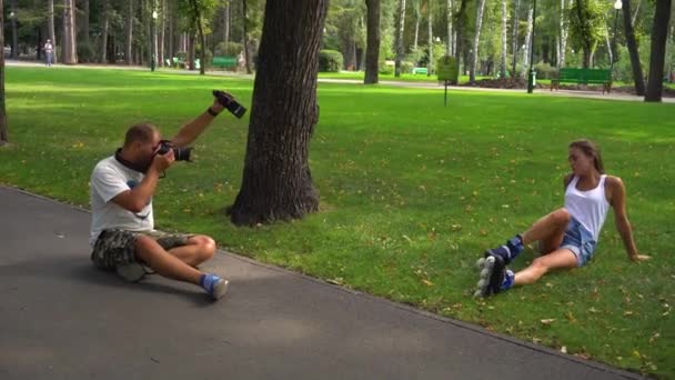 Hombre tomando fotos de mujer en patines — Vídeo de stock