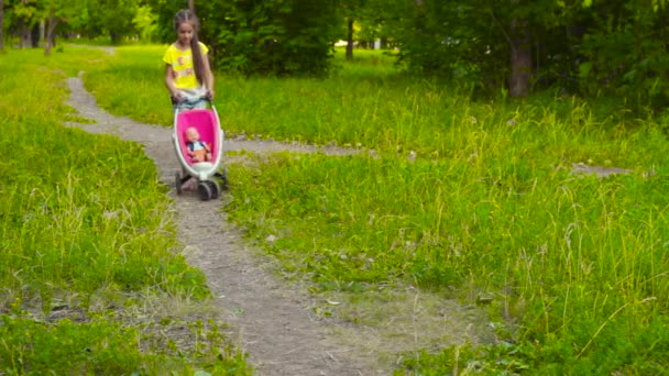 公園で赤ちゃん人形を持つ少女 — ストック動画