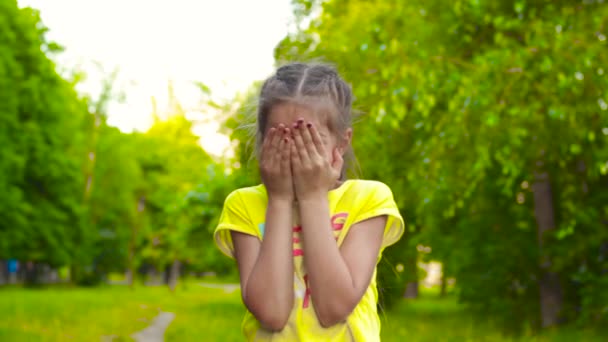 Menina jogando e se escondendo atrás das mãos — Vídeo de Stock