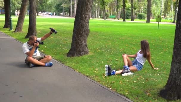 Hombre fotógrafo tomando fotos de mujer en patines — Vídeo de stock