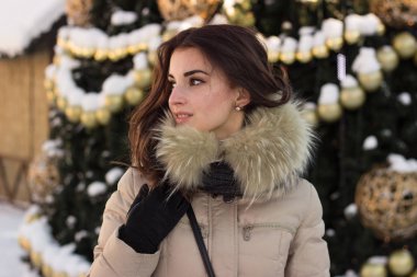 Kış parkta genç kadının yanına Noel ağacı