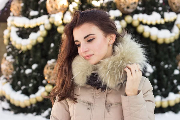 Νεαρή γυναίκα στο χειμερινό πάρκο κοντά στο χριστουγεννιάτικο δέντρο — Φωτογραφία Αρχείου