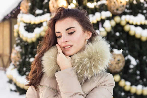 Νεαρή γυναίκα στο χειμερινό πάρκο κοντά στο χριστουγεννιάτικο δέντρο — Φωτογραφία Αρχείου