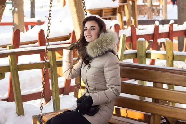 Giovane donna nel parco invernale seduta sulla panchina — Foto Stock