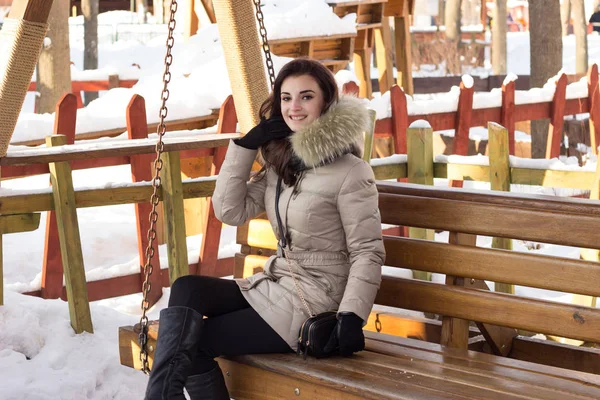 Téli Park fiatal nő ül a padon — Stock Fotó