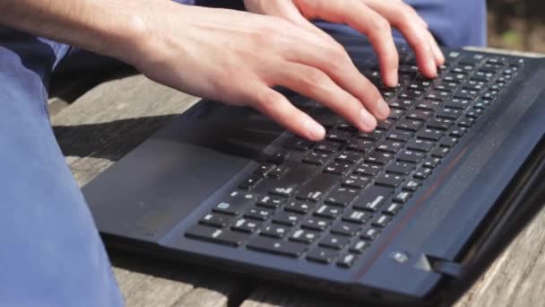 Человек-фрилансер печатает что-то на ноутбуке — стоковое видео