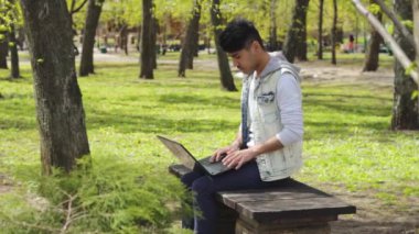Adam serbest meslek dizüstü parkta bankta oturan yaz çalışma
