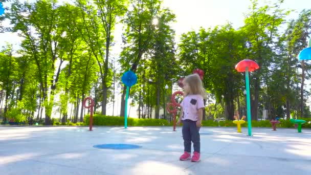 Маленька дівчинка гуляє в парку розваг — стокове відео