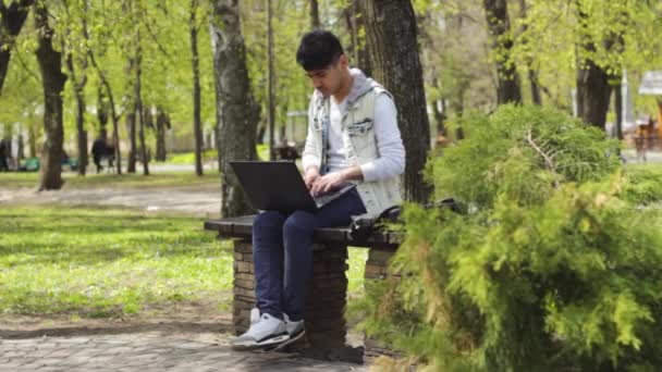 Homem asiático trabalhando no parque e depois indo embora — Vídeo de Stock