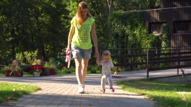 Madre e hija caminando por el sendero del parque — Vídeos de Stock
