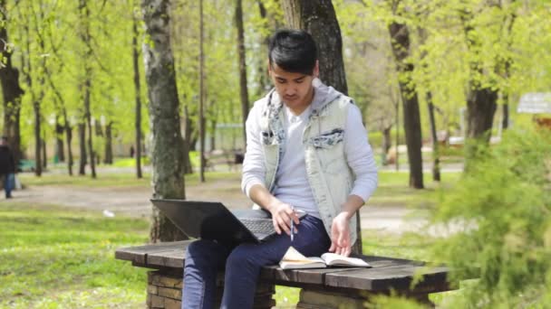 Člověk na volné noze pracuje v notebooku v parku — Stock video