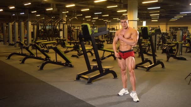 Άνθρωπος bodybuilder που θέτουν στο γυμναστήριο — Αρχείο Βίντεο