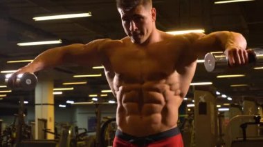 Kaslı vücut geliştirmeci atlet omuzlarında halter kaldırma