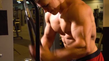 Güçlü adam vücut geliştirmeci triceps üzerinde egzersiz makinesi kullanma