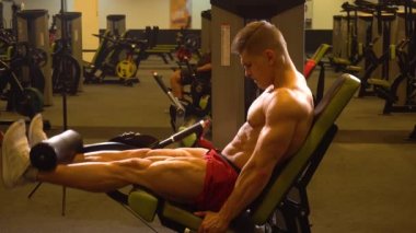 Makine üzerinde bacak egzersiz yaparak vücut geliştirmeci