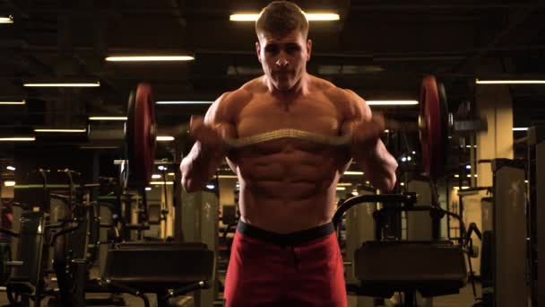 Gespierde man opheffend halter op de biceps — Stockvideo