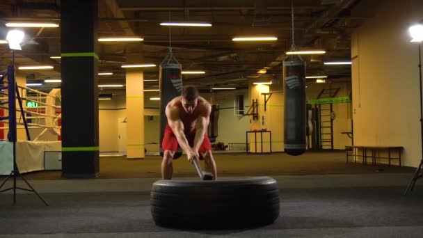 Atleta hombre golpeando neumático con martillo — Vídeos de Stock