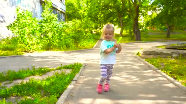 Маленькая девочка гуляла в летнем парке — стоковое видео