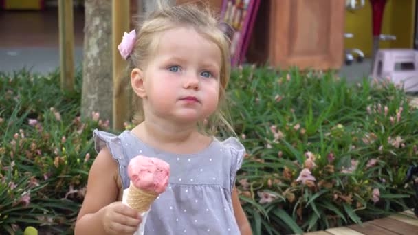 Petite fille manger de la crème glacée dans le parc — Video