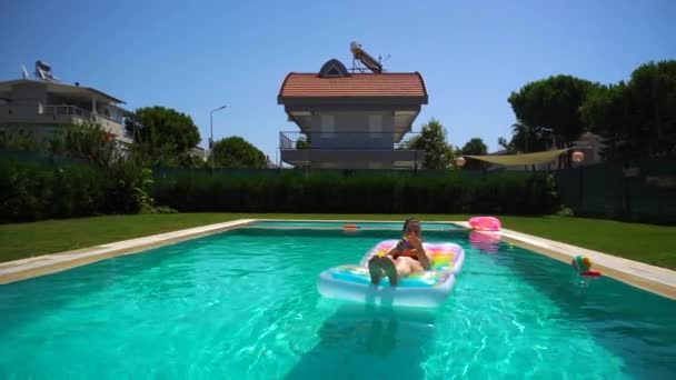 Vrouw gebruik zonnebrand crème en liggend op zwembad float — Stockvideo