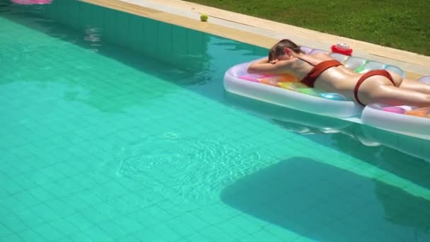 Mulher deitada na piscina flutuar e desfrutar de verão — Vídeo de Stock