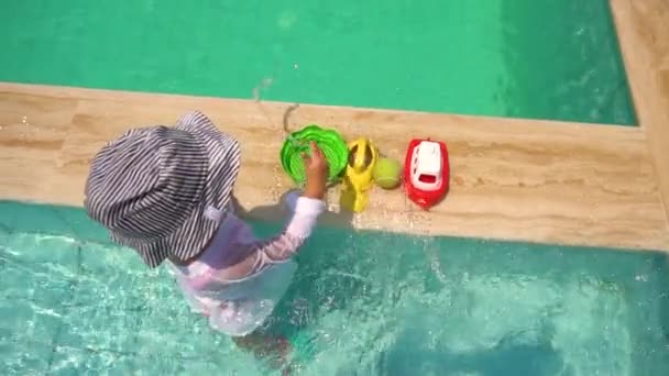 Chica jugando con juguetes en la piscina — Vídeos de Stock