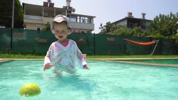 Flicka som leker med tennisboll i poolen i slow motion — Stockvideo