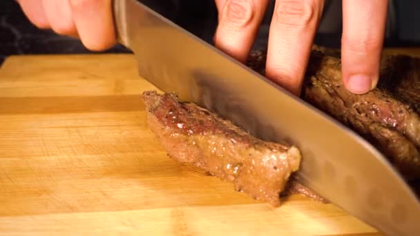 Ręce krojenie gotowanego mięsa wołowego na pokładzie cięcia — Wideo stockowe