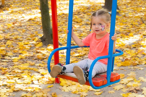 Meisje op schommel in herfst park swingen — Stockfoto