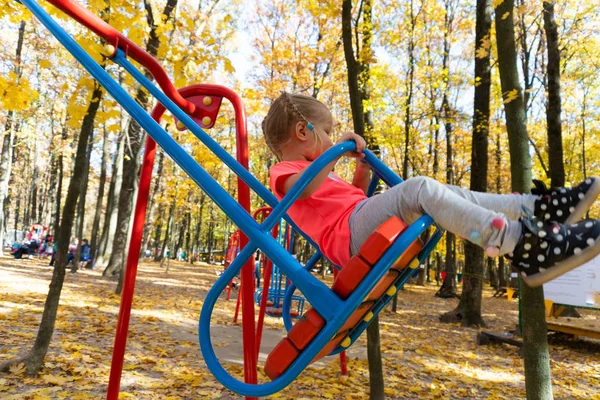 Meisje swingen op schommel in kinderen park — Stockfoto