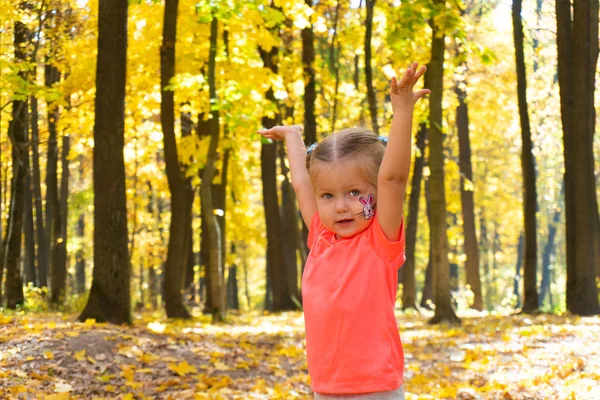 Menina feliz jogando no outono Park — Fotografia de Stock