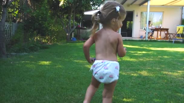 Petite fille courir et tomber sur la pelouse — Video